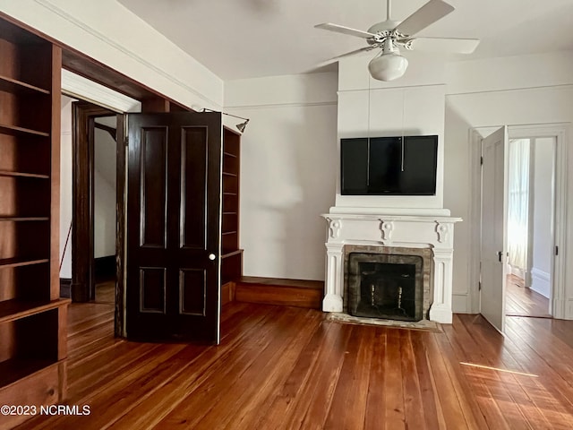 unfurnished living room with dark hardwood / wood-style flooring and ceiling fan