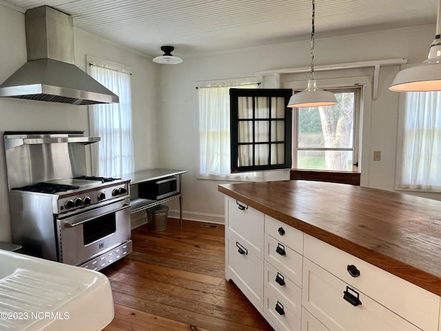 kitchen featuring wall chimney exhaust hood, white cabinetry, wooden counters, hanging light fixtures, and stainless steel appliances