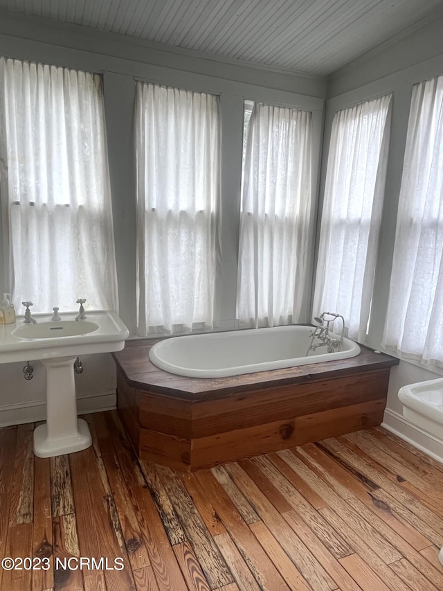 bathroom with wood-type flooring and a tub