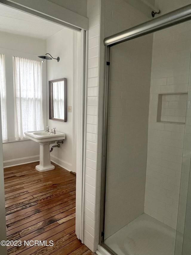 bathroom featuring wood-type flooring and an enclosed shower