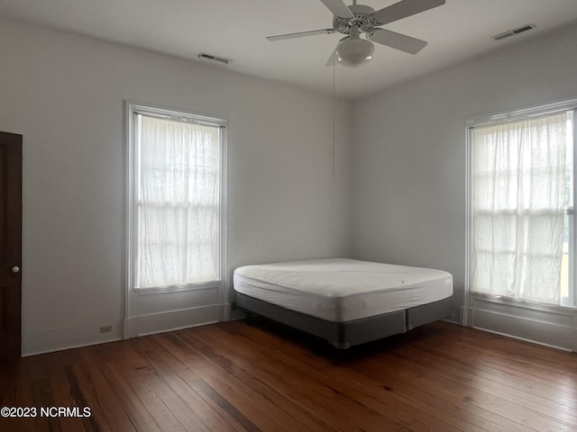 unfurnished bedroom featuring ceiling fan and dark hardwood / wood-style floors