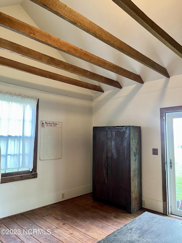 unfurnished bedroom with wood-type flooring and lofted ceiling with beams