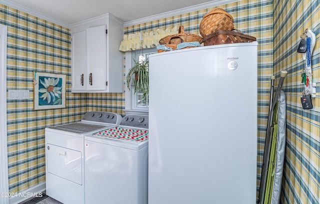 clothes washing area with cabinets and washing machine and clothes dryer