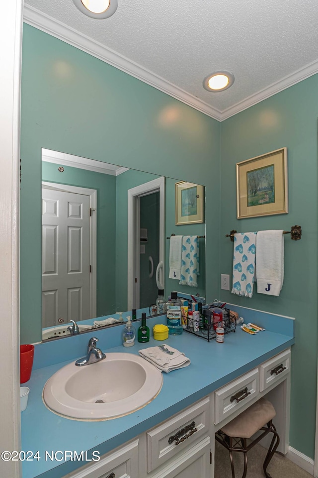 bathroom featuring vanity, ornamental molding, and a textured ceiling