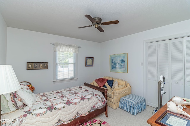 carpeted bedroom featuring ceiling fan, a closet, and a textured ceiling