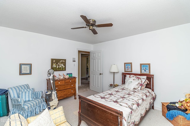 carpeted bedroom with ceiling fan and a textured ceiling