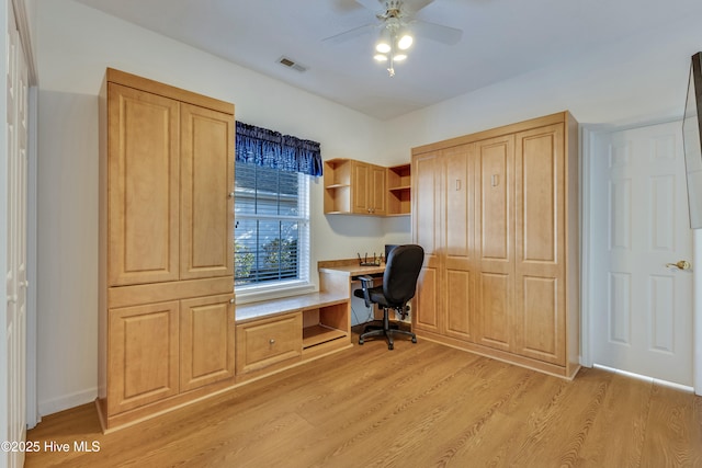 office area featuring ceiling fan, built in desk, and light hardwood / wood-style flooring