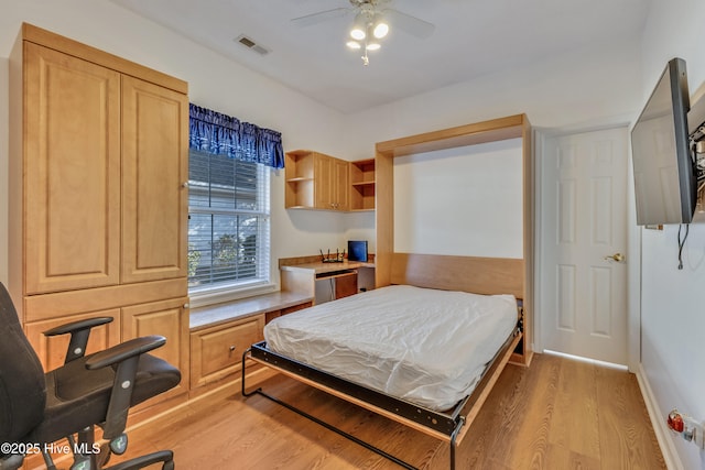 bedroom with built in desk and light hardwood / wood-style flooring