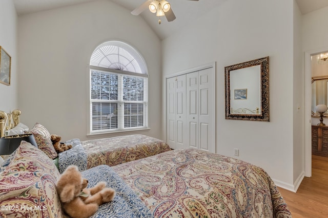 bedroom featuring vaulted ceiling, a closet, ceiling fan, and light wood-type flooring