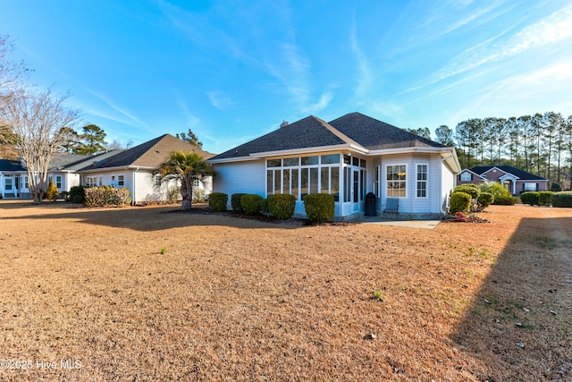 single story home featuring a patio area, a front lawn, and a sunroom