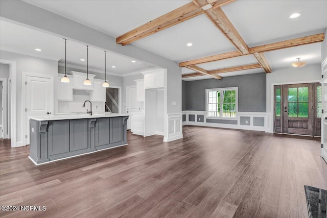 kitchen with a spacious island, white cabinetry, hanging light fixtures, and beamed ceiling