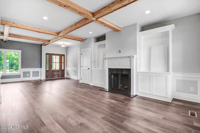 unfurnished living room with beamed ceiling and wood-type flooring