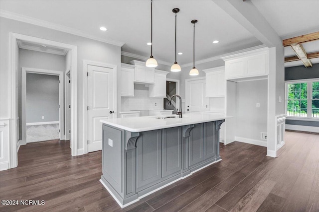 kitchen with a spacious island, sink, white cabinetry, hanging light fixtures, and dark hardwood / wood-style floors