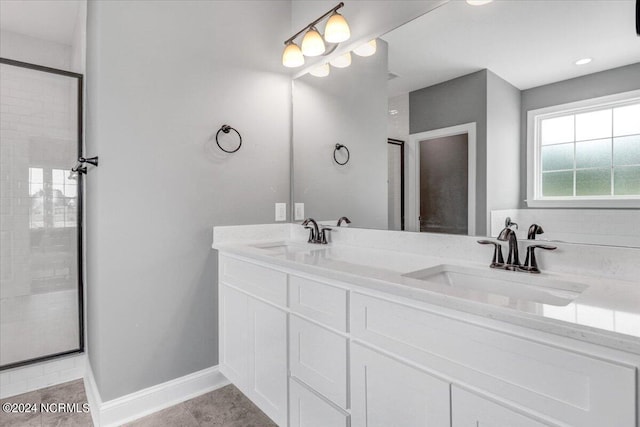 bathroom featuring a shower with door and vanity