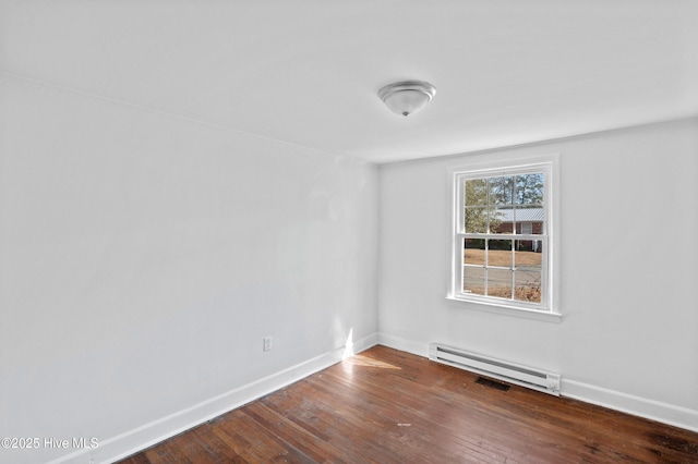 spare room featuring a baseboard radiator and dark hardwood / wood-style floors