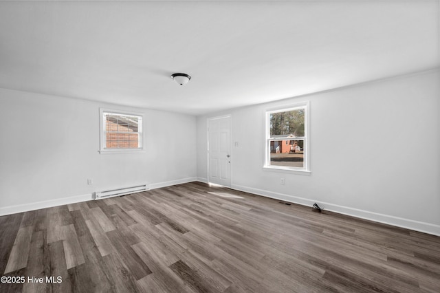 empty room featuring a baseboard radiator and dark hardwood / wood-style floors