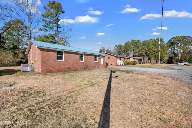 exterior space with a front yard and central air condition unit