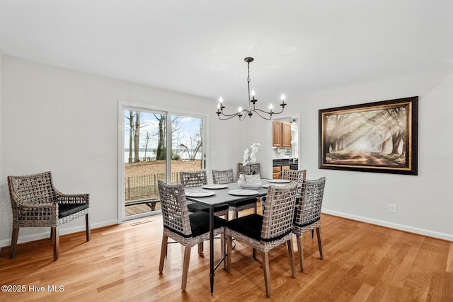 dining space with a chandelier and light hardwood / wood-style flooring