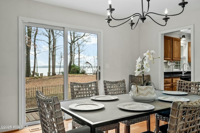 dining space with a notable chandelier and a water view