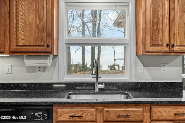 kitchen featuring sink, a wealth of natural light, dark stone counters, and dishwasher