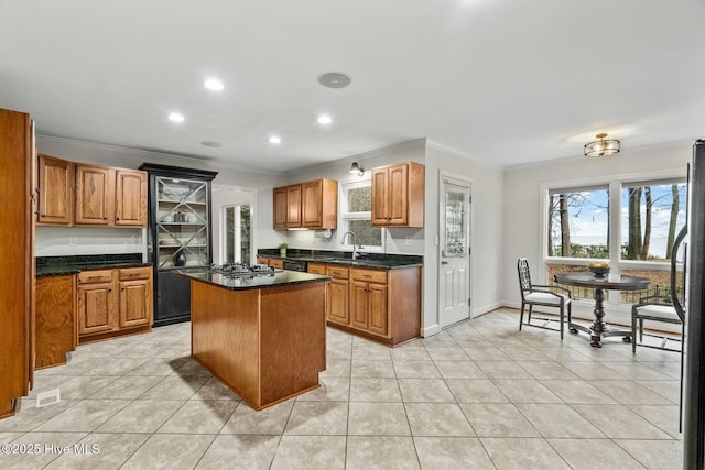 kitchen featuring light tile patterned floors, crown molding, sink, and a kitchen island