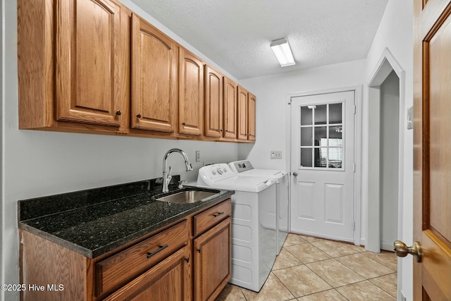 washroom featuring sink, cabinets, light tile patterned floors, independent washer and dryer, and a textured ceiling