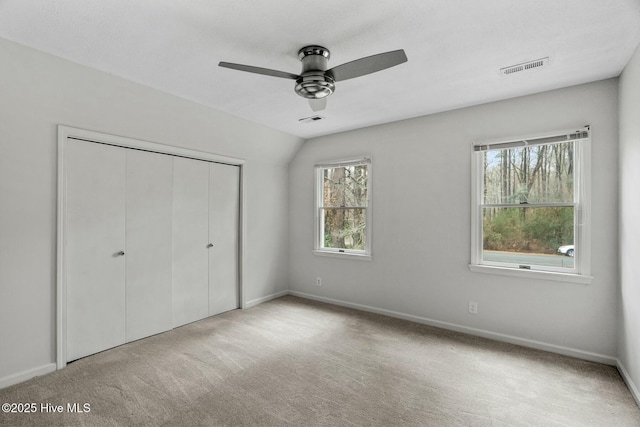 unfurnished bedroom with light carpet, a closet, and ceiling fan