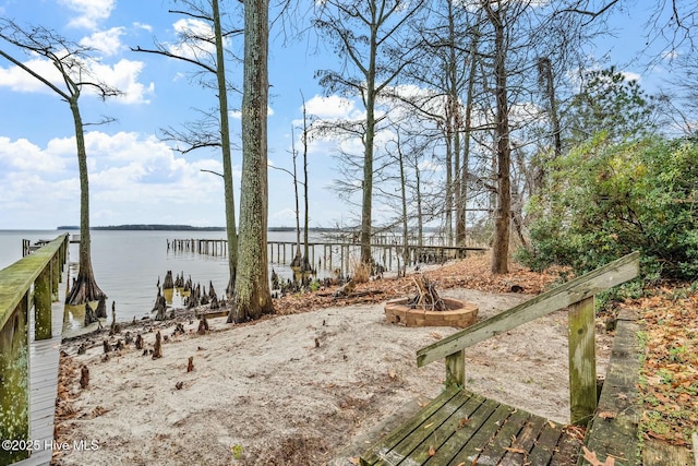 view of yard featuring a water view and an outdoor fire pit