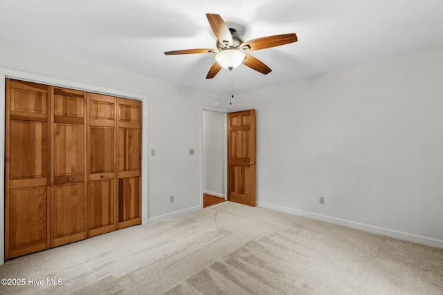 unfurnished bedroom with light carpet, a closet, and ceiling fan