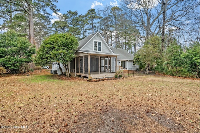 rear view of house featuring a yard, central AC, and a sunroom