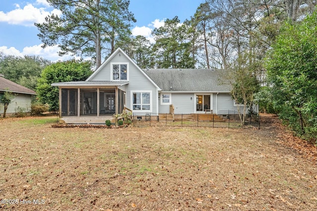 back of property featuring a sunroom and a lawn