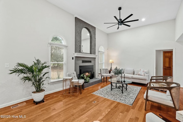 living room featuring hardwood / wood-style flooring, ceiling fan, plenty of natural light, and a fireplace