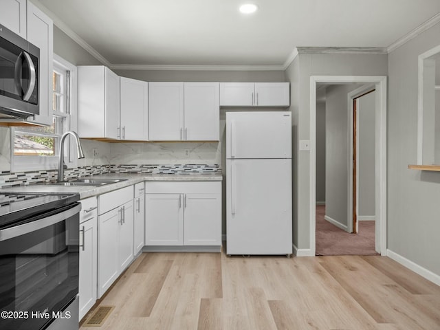 kitchen featuring stainless steel appliances, white cabinetry, sink, and ornamental molding