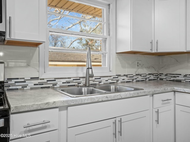 kitchen featuring white cabinetry, sink, and decorative backsplash