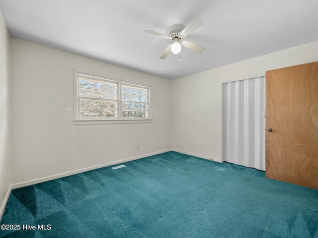 carpeted spare room with ceiling fan