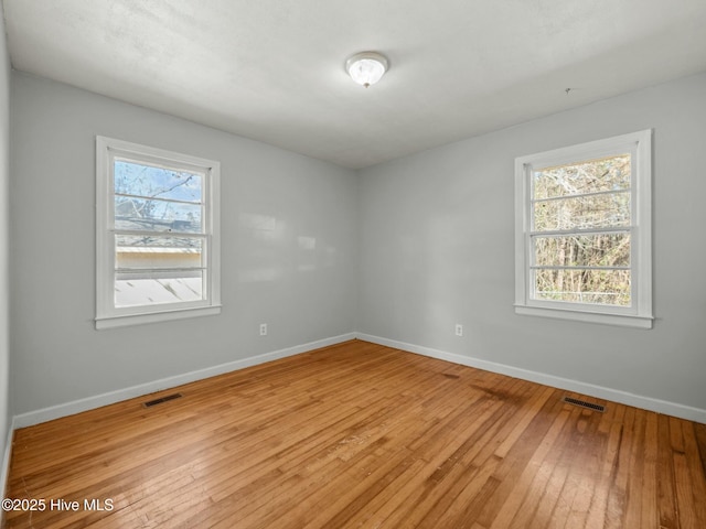 empty room with a healthy amount of sunlight and light wood-type flooring