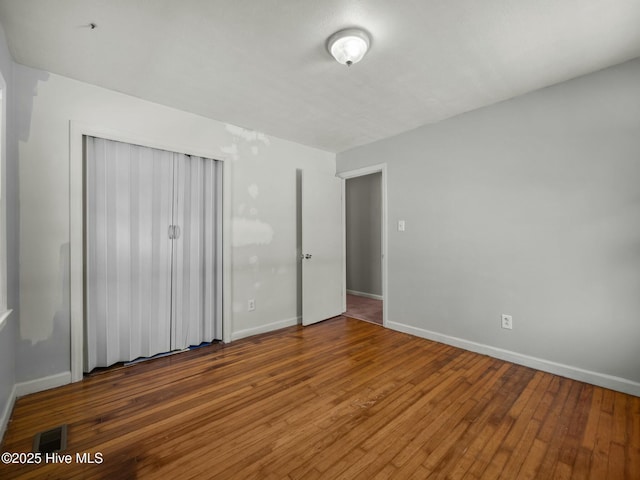 unfurnished bedroom featuring hardwood / wood-style flooring and a closet