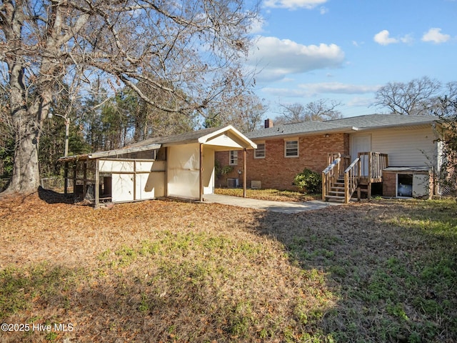 back of property featuring central AC unit and a lawn