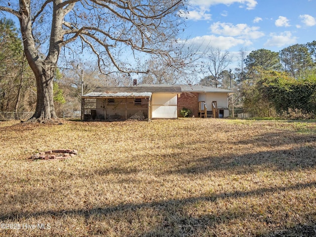 rear view of property featuring a lawn