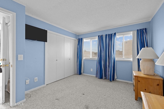 carpeted bedroom featuring a textured ceiling and a closet