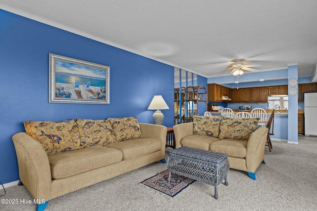 carpeted living room featuring sink and ceiling fan