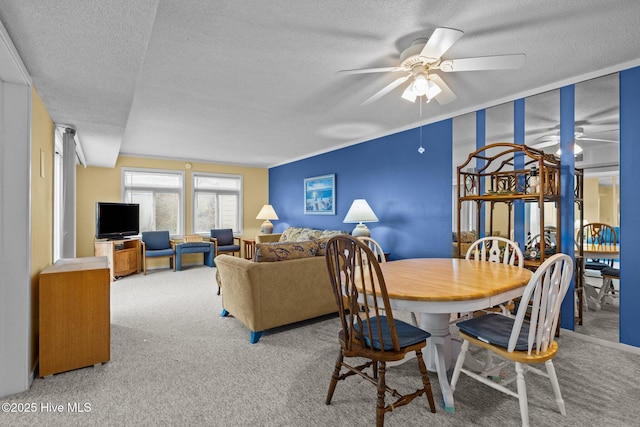 carpeted dining area featuring a textured ceiling and ceiling fan