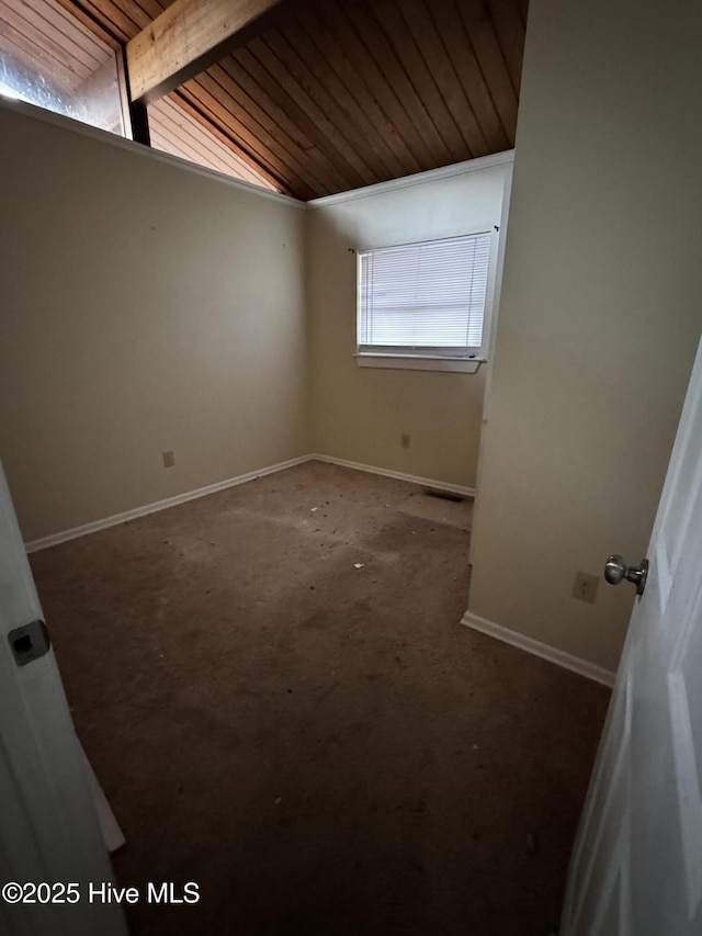 empty room featuring lofted ceiling with beams and wooden ceiling