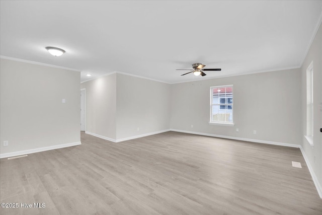 spare room with ceiling fan, ornamental molding, light wood-style flooring, and baseboards