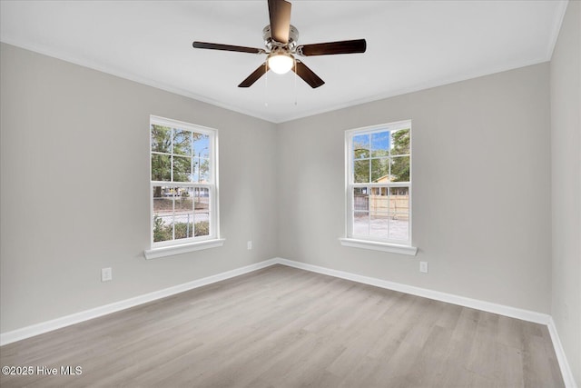 unfurnished room with crown molding, light wood finished floors, a ceiling fan, and baseboards