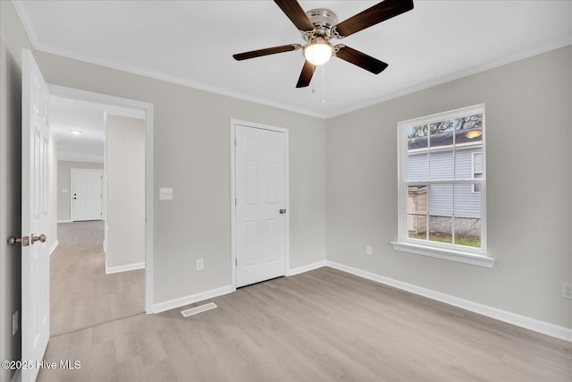 unfurnished bedroom with ornamental molding, visible vents, light wood-style flooring, and baseboards