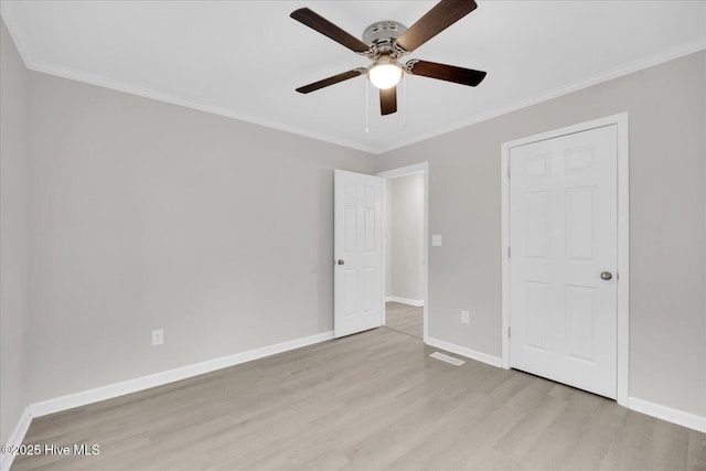 unfurnished bedroom featuring light wood-style flooring, baseboards, ceiling fan, and ornamental molding