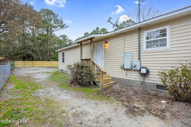 back of house with crawl space, a fenced backyard, and dirt driveway