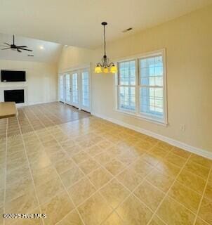 unfurnished living room featuring lofted ceiling and ceiling fan with notable chandelier