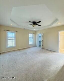 empty room featuring a raised ceiling and ceiling fan